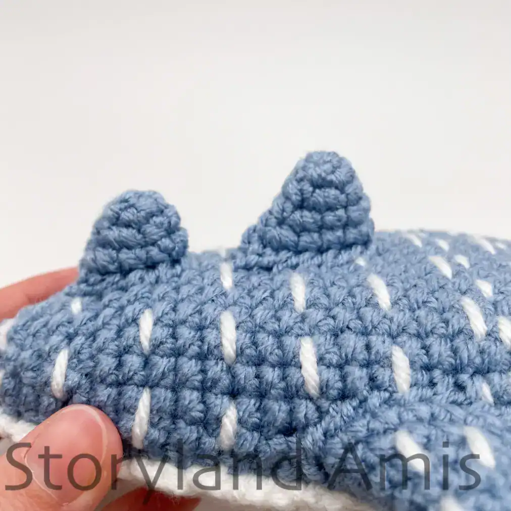 The back fins on an amigurumi whale shark are shown from the side.