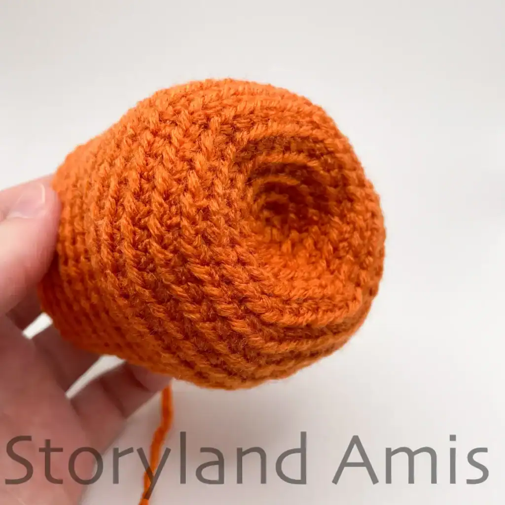 A close-up of the bottom of a partially finished amigurumi pumpkin.