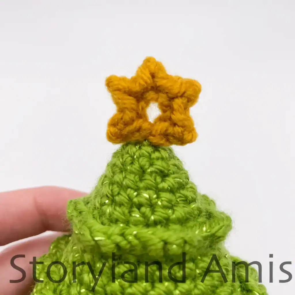 A close-up of the top of an amigurumi Christmas tree and the crocheted star on top.