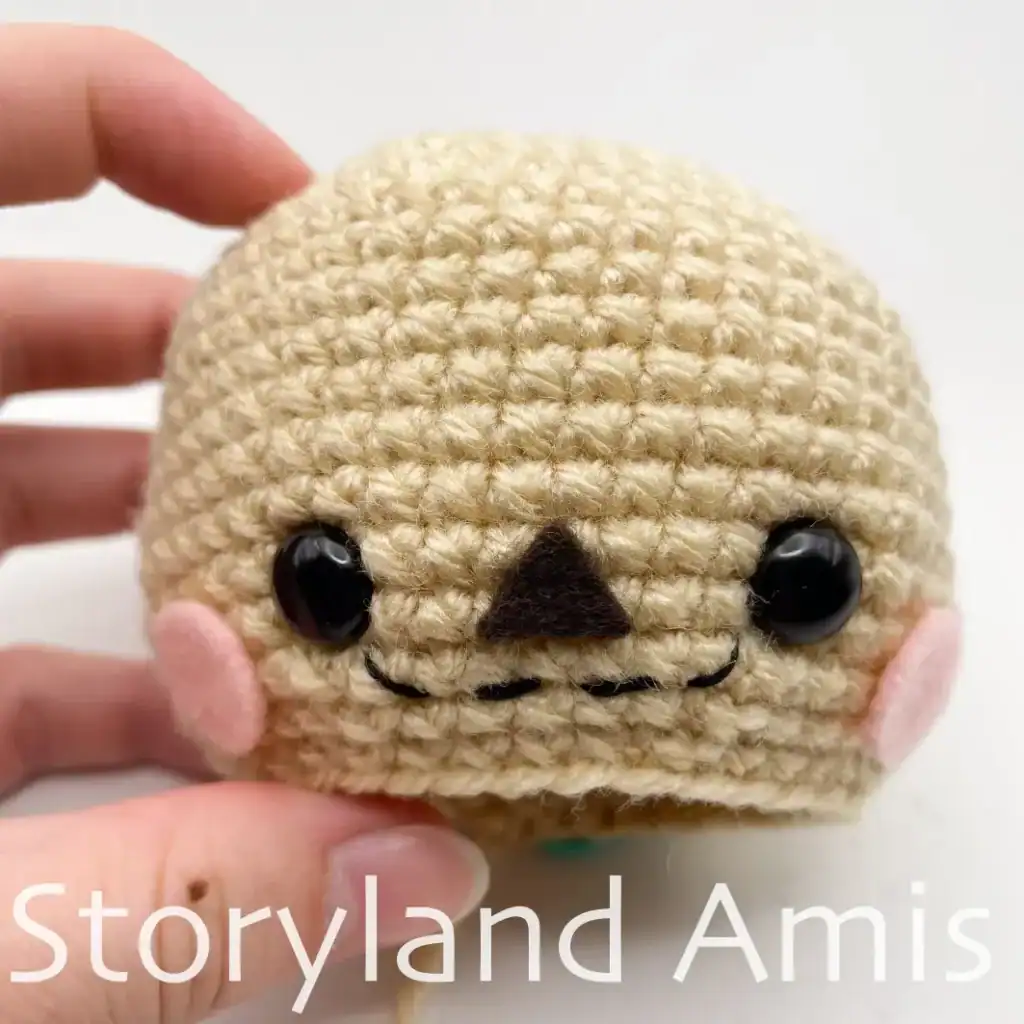 Close-up of a partially finished amigurumi scarecrow head.