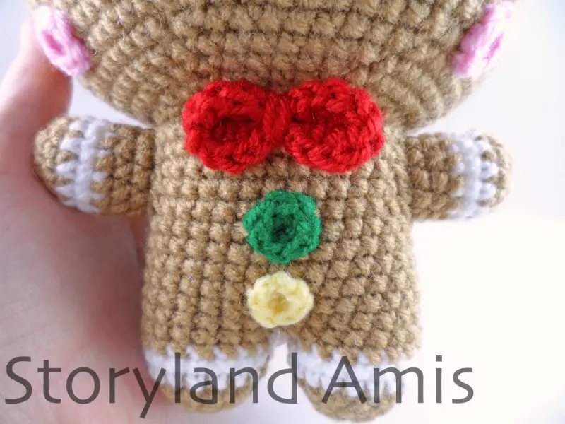 A close-up of the front of an amigurumi gingerbread man's body.