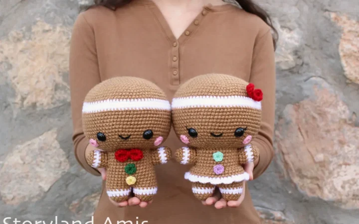 A girl holds a crocheted gingerbread man and girl.