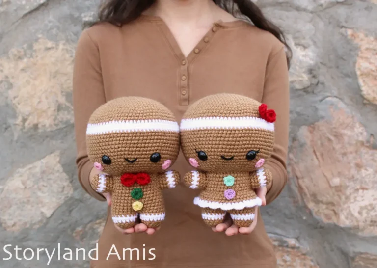A girl holds a crocheted gingerbread man and girl.