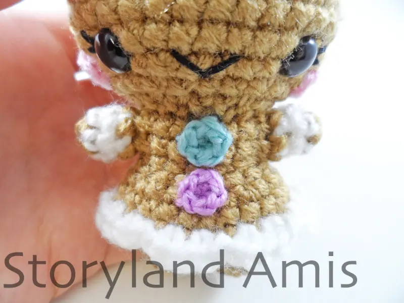 A close-up of the front of the body of an amigurumi gingerbread girl.