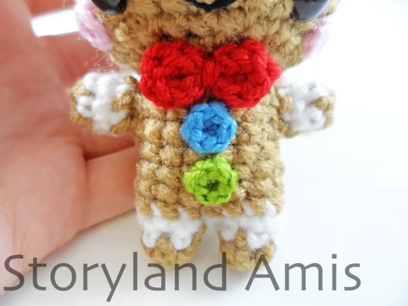A close-up of the front of the body of an amigurumi gingerbread boy.