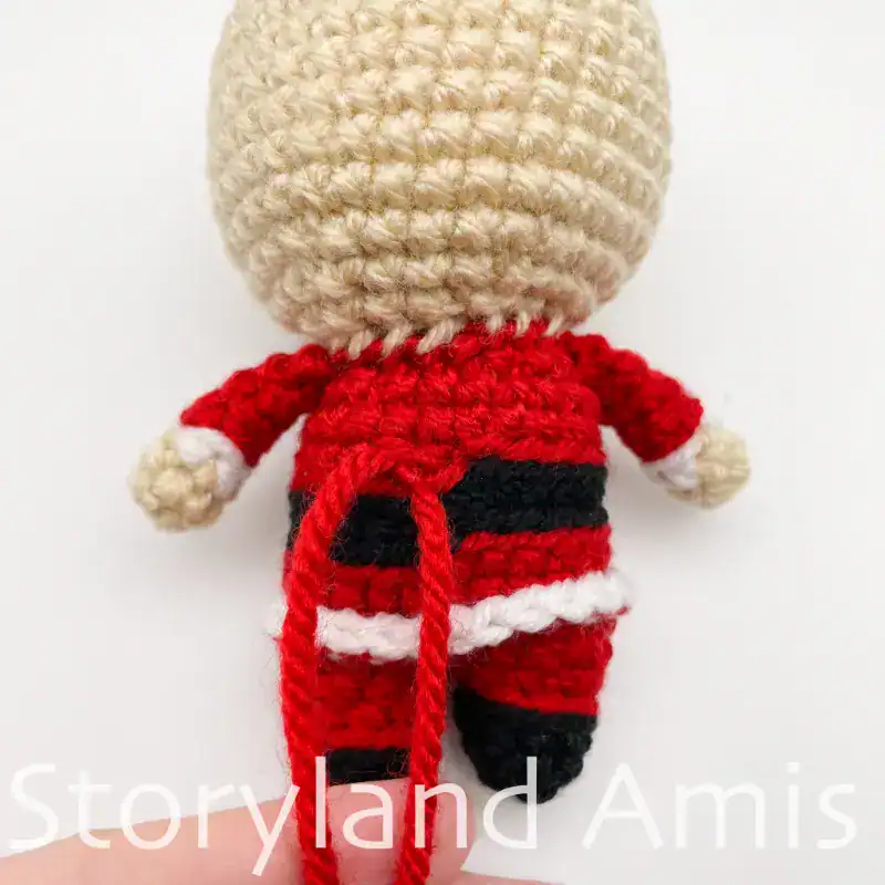 A close-up of the back of a partially finished amigurumi Santa Claus.