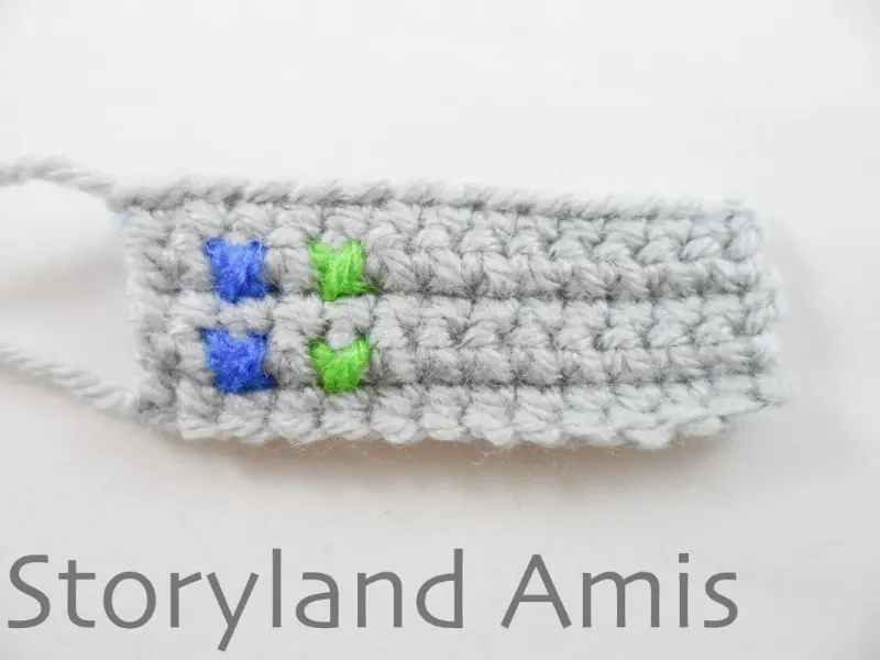 A gray crocheted rectangle lies on a white background.