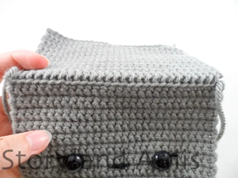 A close-up of the top edge of a partially finished amigurumi robot head.