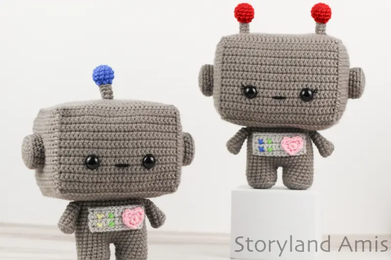 Two crocheted robot amigurumi toys.