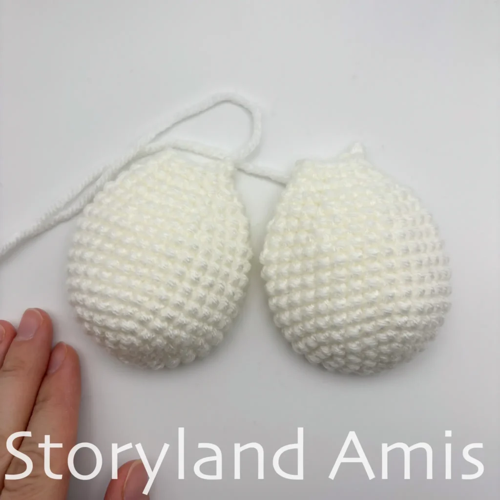 Two white crocheted bee wings lay on a white table.