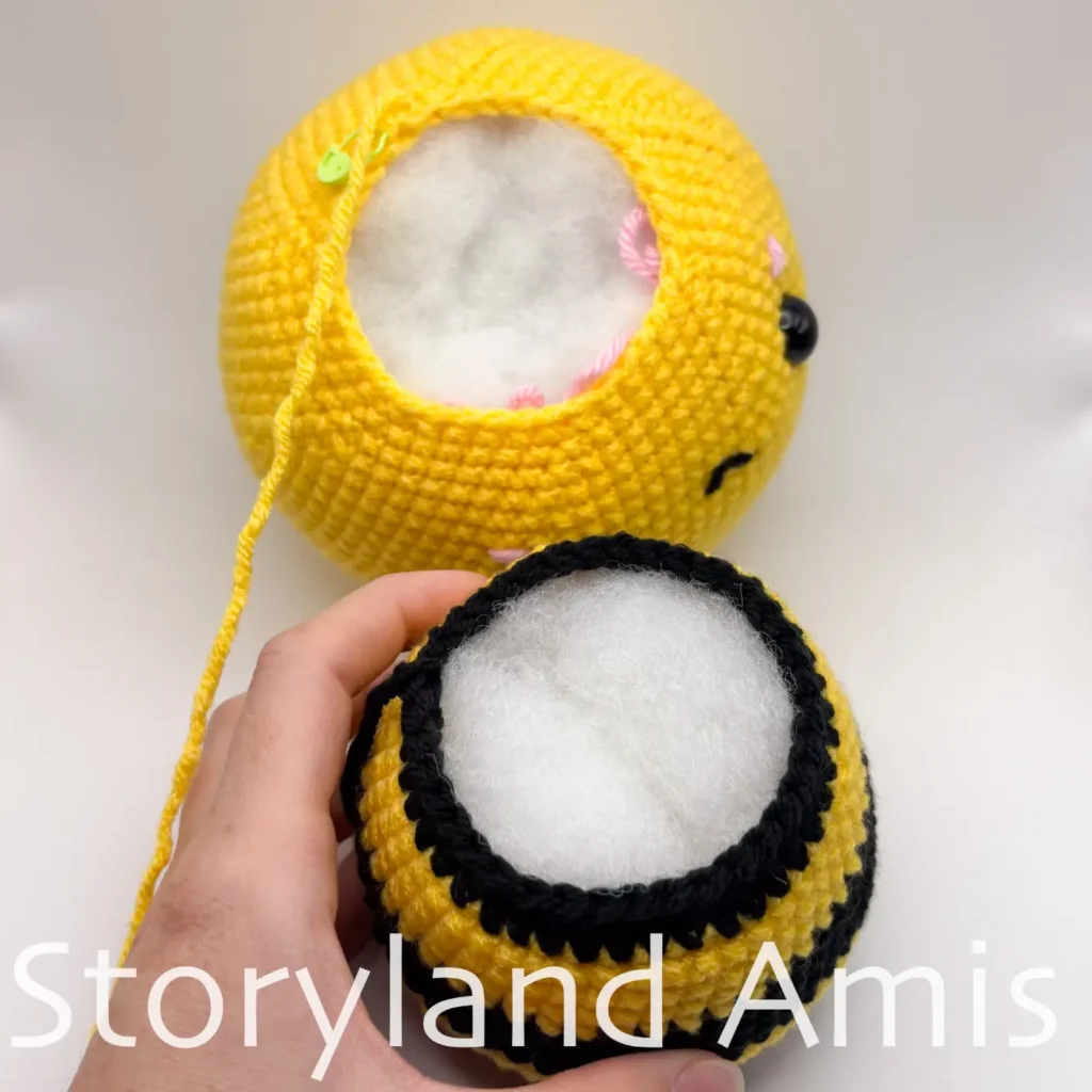 A crocheted bee's head and body, side-by-side, shown from the top.