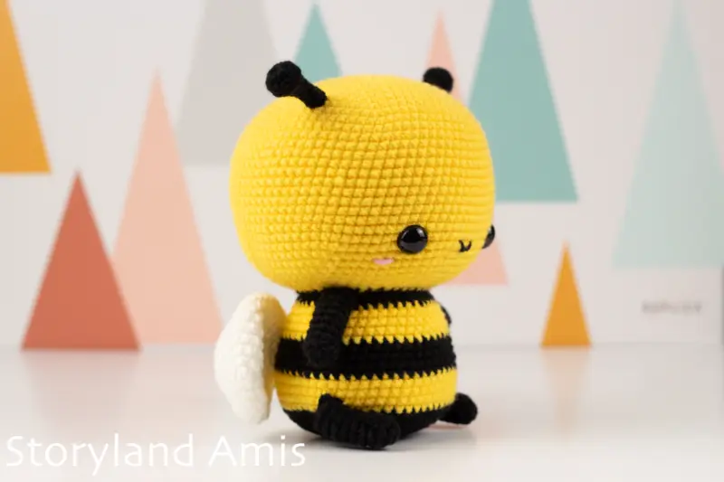 An amigurumi bee is shown from the side.