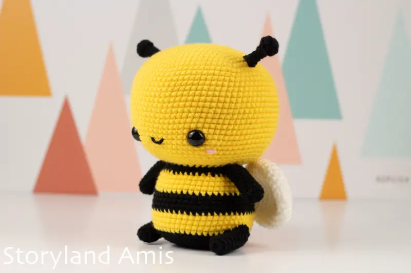 An amigurumi bee is shown from the side.