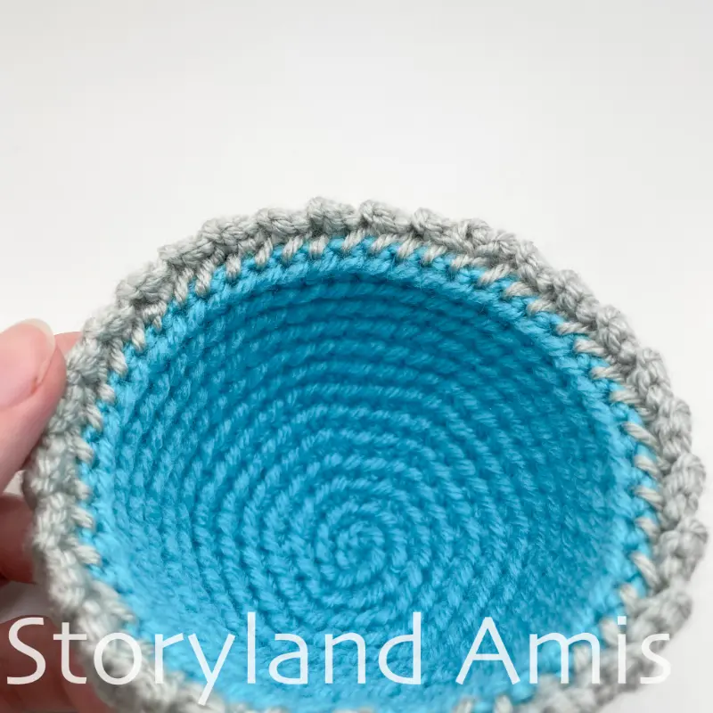 A close-up of the inside edge of a small crocheted stocking cap.