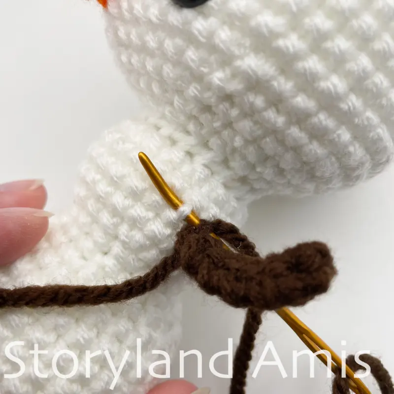A close-up shows how to sew a crocheted arm to the body of an amigurumi snowman.