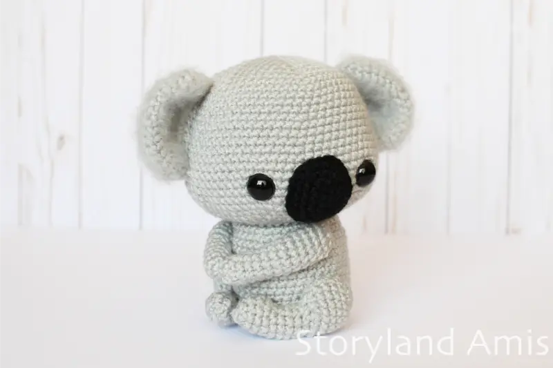 An amigurumi koala sits on a white table.