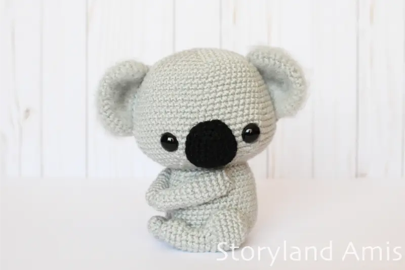 An amigurumi koala sits on a white table.