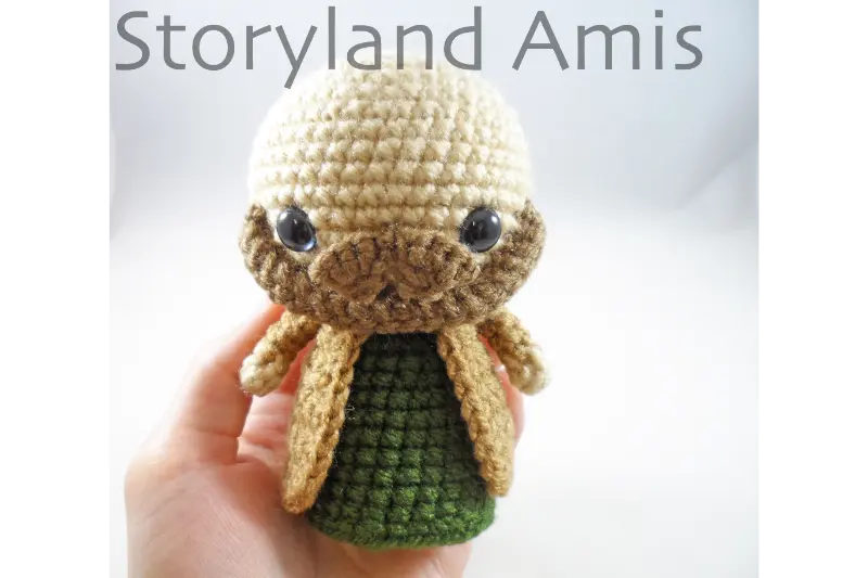 A hand holds a partially finished amigurumi Joseph doll for a crochet nativity set.