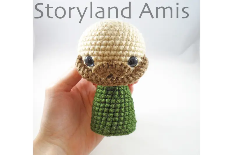 A hand holds a partially finished amigurumi doll meant to be part of a crocheted Nativity set