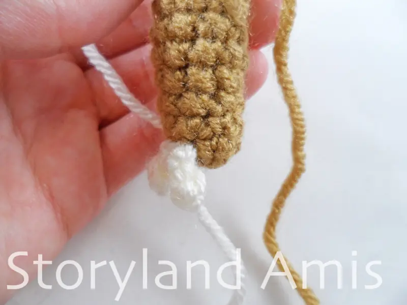 A close-up of the bottom of a crocheted sloth arm.