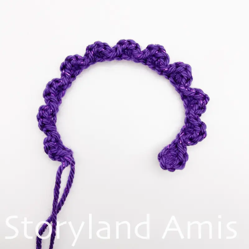 A crocheted scalloped chain lies on a white background.