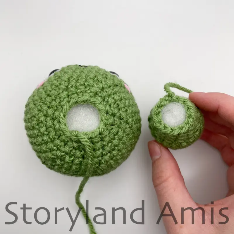A green crocheted tortoise head and body lay side by side on a white background. 