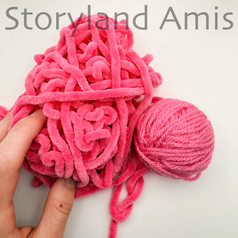 a pile of plush pink yarn lies next to a ball of pink worsted-weight yarn. 