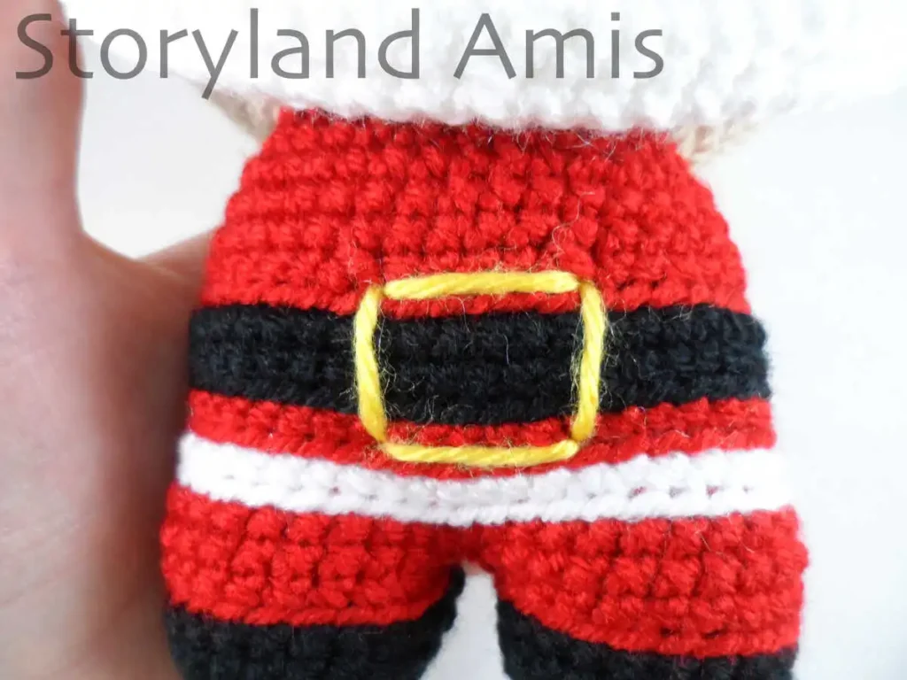 A close-up of the body on a crocheted amigurumi Santa Claus.