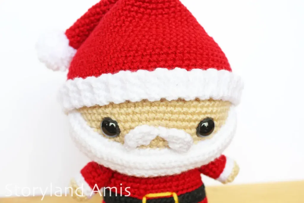A close-up of an amigurumi Santa Claus doll.