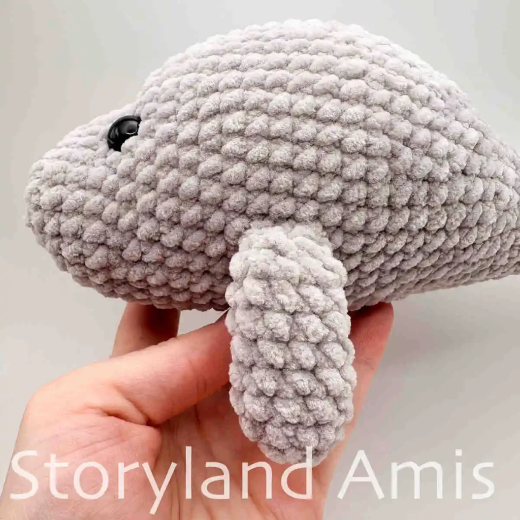 A close-up of a flipper on a crocheted amigurumi manatee toy.